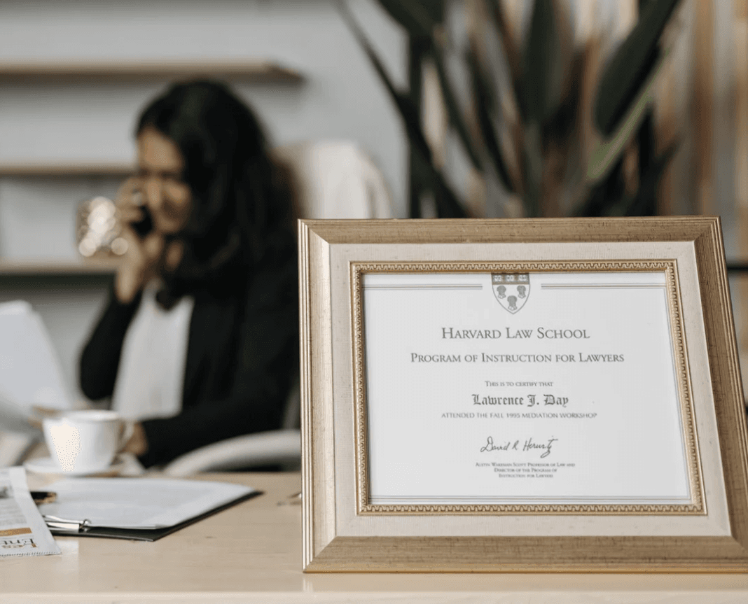 Photo of a lawyer with a framed degree from Harvard Law School.